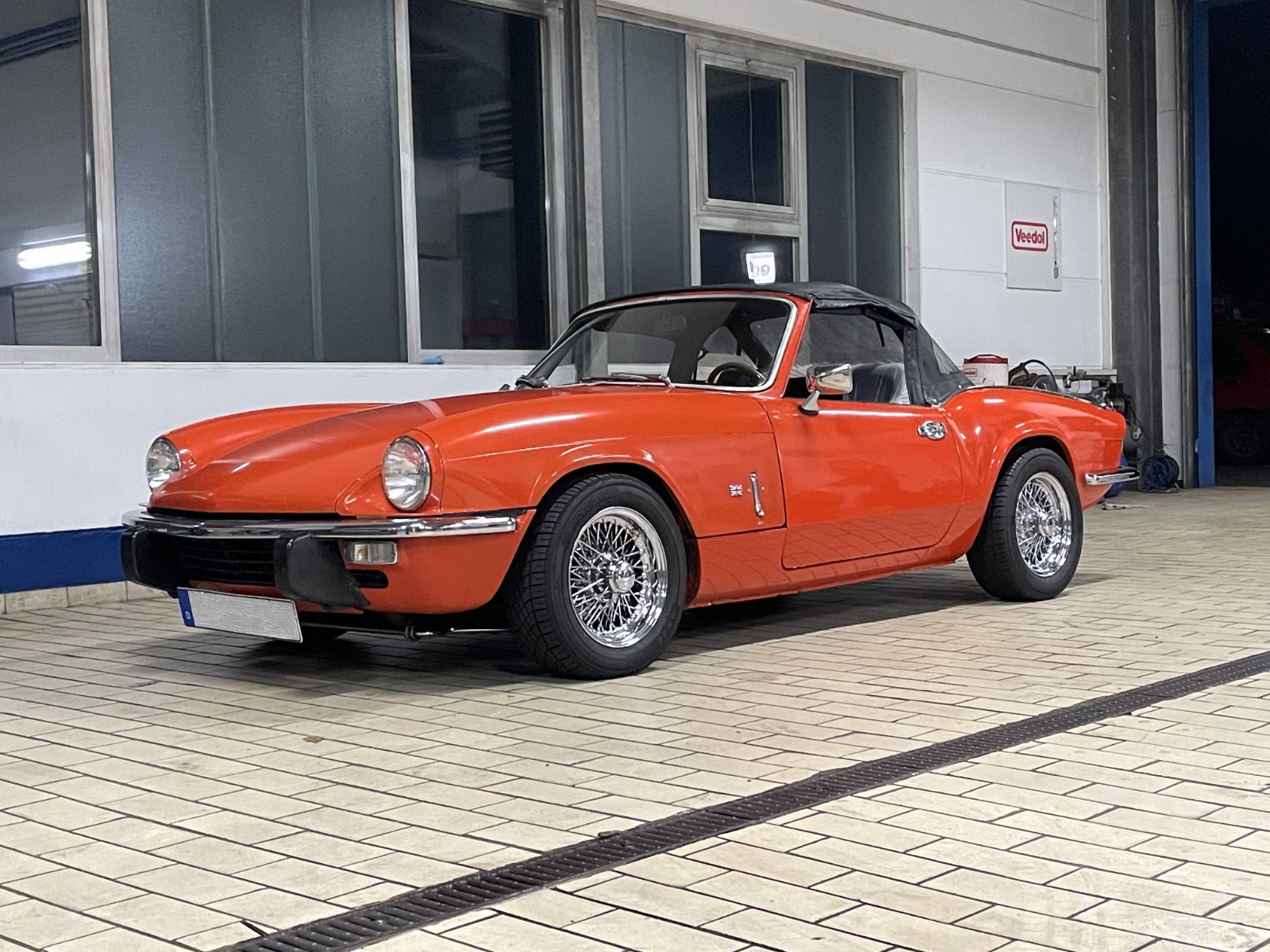 Triumph Spitfire Oldtimer vor der Werkstatthalle