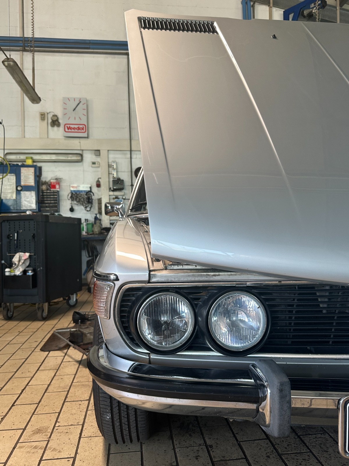 Klassischer BMW mit geöffneter Motorhaube in der Werkstatt